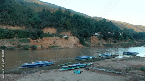 View of the river and boats in the town Muang Khoua, Laos.  
 photo