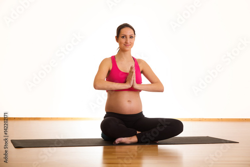 Schwangere junge Frau macht Yoga © dadima