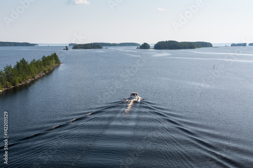 Landscape of Saimaa lake, ship and wake wave on calm water from above, Finland. photo