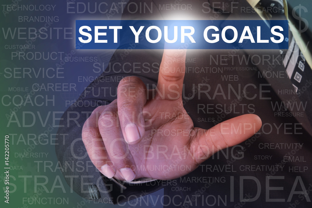 Businessman touching SET YOUR GOALS button on virtual screen Businessman touching SET YOUR GOALS button on virtual screen