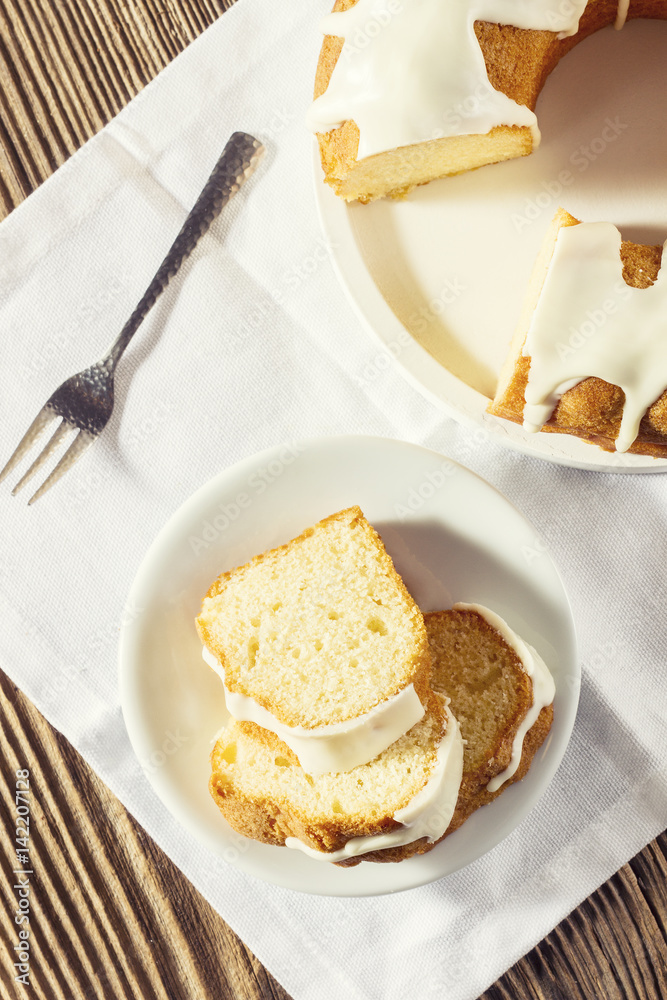 Slices of glazed easter cake and sliver fork on a white linen cloth, top view Slices of glazed easter cake and sliver fork on a white linen cloth, top view
