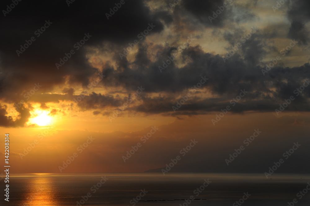 Off-centered sunset with dramatic dark clouds in Tenerife, Canary Islands