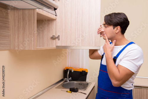 Young man assembling kitchen furniture