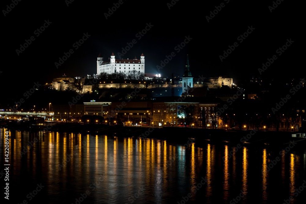 Bratislava, Slovakia - March 19, 2017: Night view of Bratislava castle and Danune river in capital city of Slovakia with its reflection