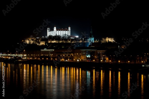 Bratislava, Slovakia - March 19, 2017: Night view of Bratislava castle and Danune river in capital city of Slovakia with its reflection