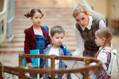 Valokuva Teacher guiding schoolkids in museum of national history
