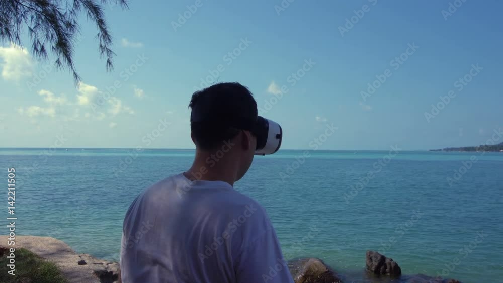 Man in Virtual Reality Glasses Looking at the Sea