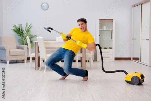 Man playing virtual guitar with vacuum cleaner