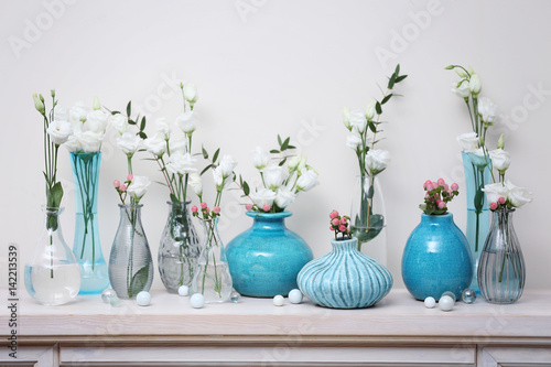 Принти на полотні Beautiful composition with fresh flowers in vases on mantelpiece