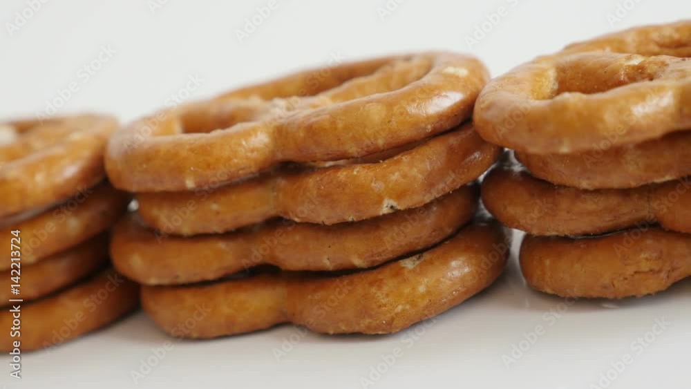Close-up of popular snack food pretzel on white background slow pan 4K 2160p 30fps UltraHD footage - Panning on piles of baked bread product made from dough 3840X2160 UHD video 