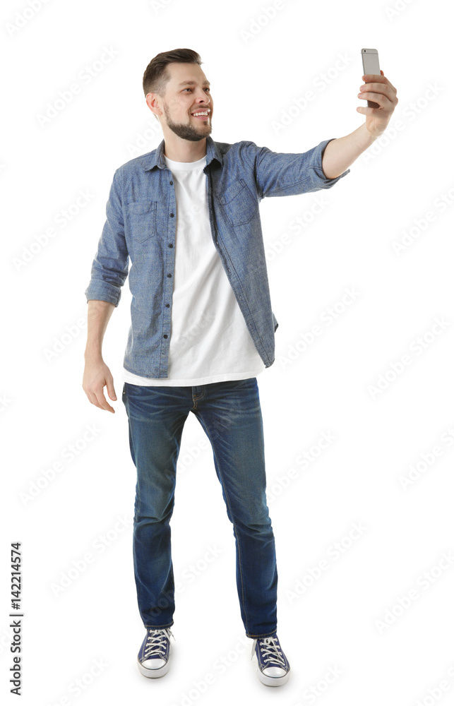 Handsome young man taking selfie on white background