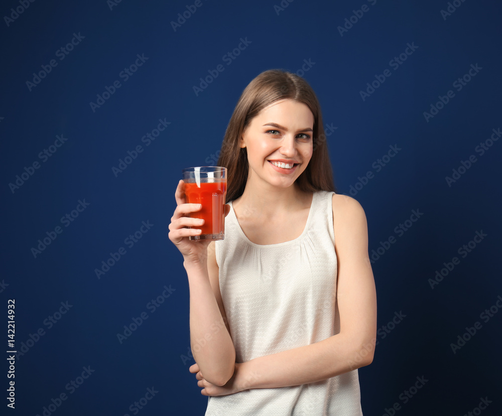 Beautiful young woman with glass of fresh juice on dark blue background Beautiful young woman with glass of fresh juice on dark blue background