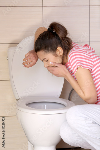 Canvas Print Young vomiting woman near toilet bowl at home