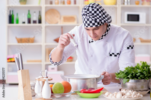 Young male cook working in the kitchen © Elnur