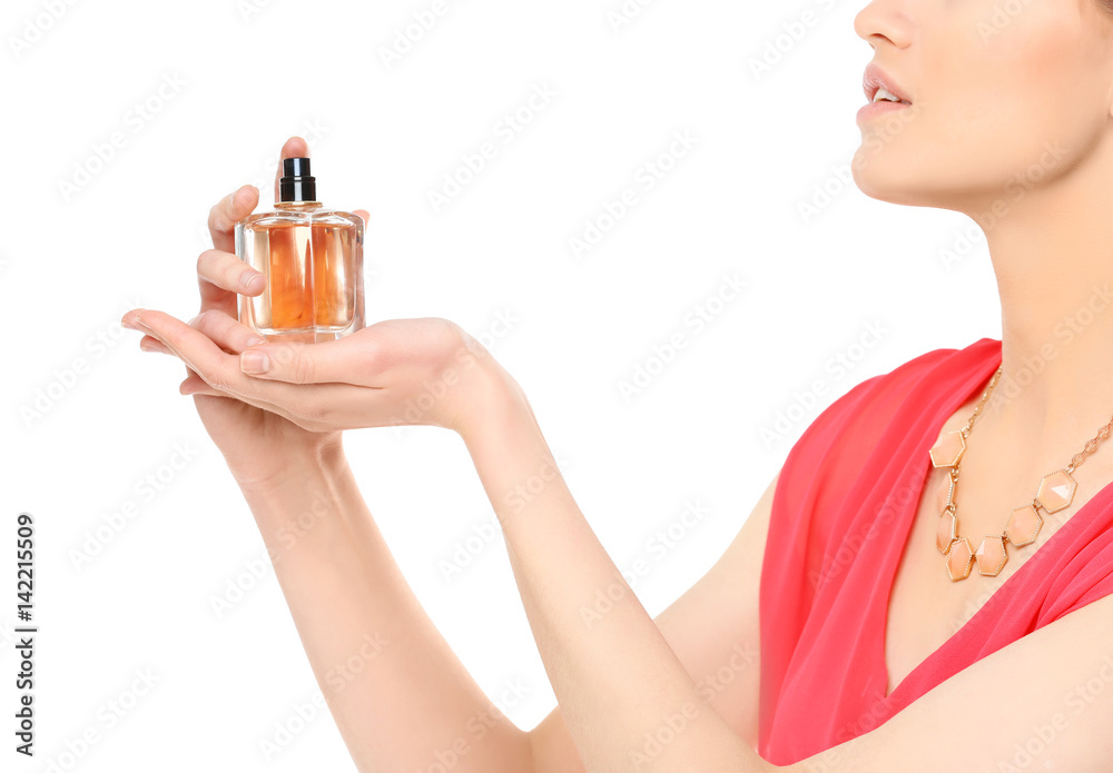 Fototapeta premium Beautiful young woman with bottle of perfume on white background