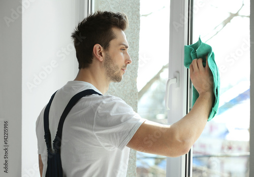 Young man cleaning window i...