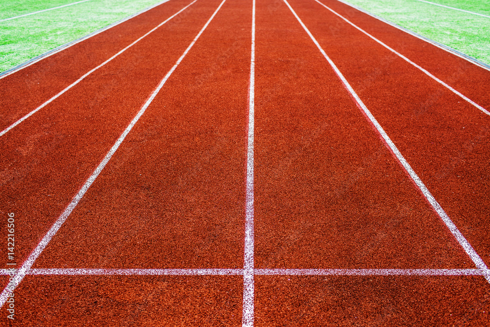 Running Track . Red treadmill at the stadium with white lines .