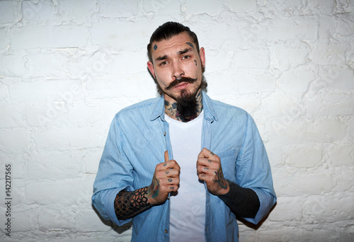 Photos Saturated flash portrait of modern creative man: with beard, moustache and tatto
