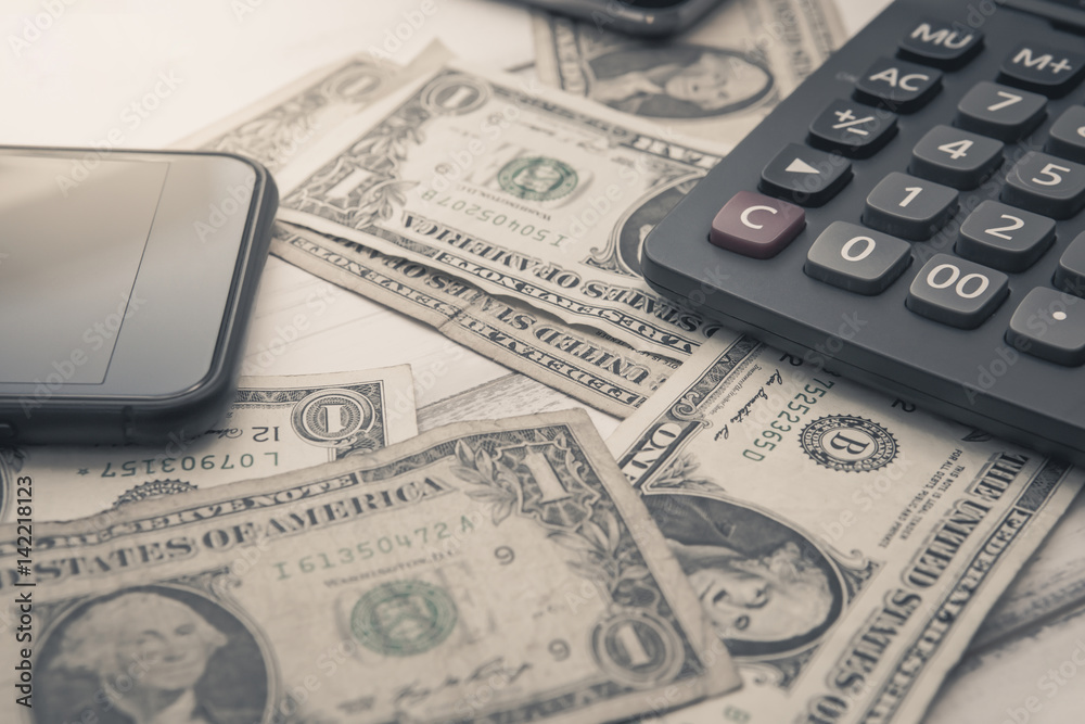 Calculator with american dollars on the wooden table background, finance concept, pencil, phone Calculator with american dollars on the wooden table background, finance concept, pencil, phone