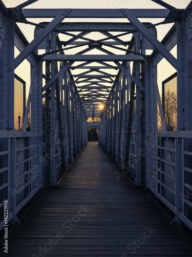 Fototapet Symmetry view of footbridge over railway track at sunset