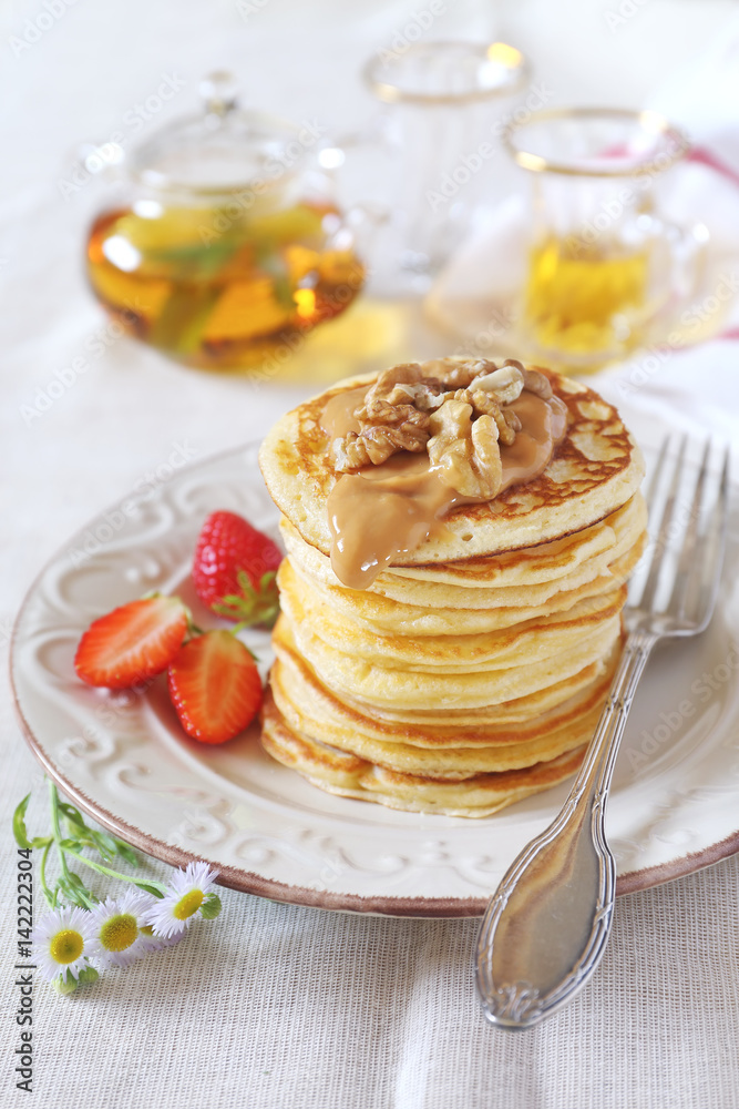 Pancakes with strawberries, caramel cream, walnuts and mint tea