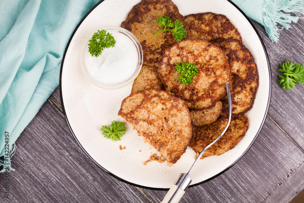 Liver Patties with Sour Cream and Parsley. Liver Cakes or Fritters of Liver. Healthy snack or take-away lunch bites. View from above, top studio shot Liver Patties with Sour Cream and Parsley. Liver Cakes or Fritters of Liver. Healthy snack or take-away lunch bites. View from above, top studio shot