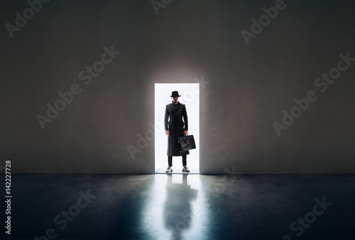 Photography Man silhouette standing in the light of opening door in dark room