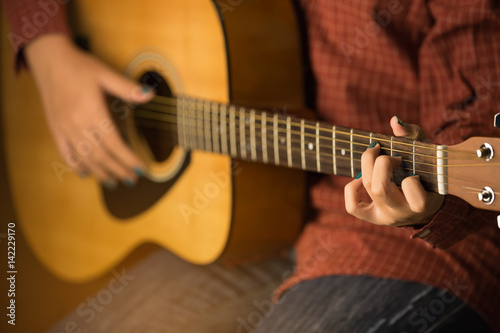 women playing acoustic guitar close-up
