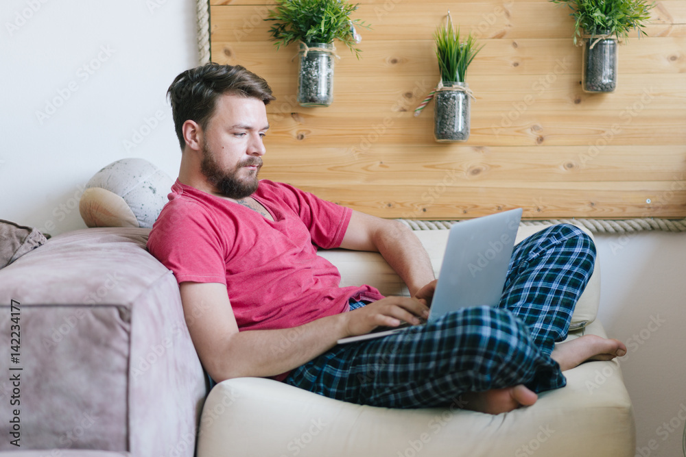 Young Caucasian man using his lap top at his home. Young Caucasian man using his lap top at his home.