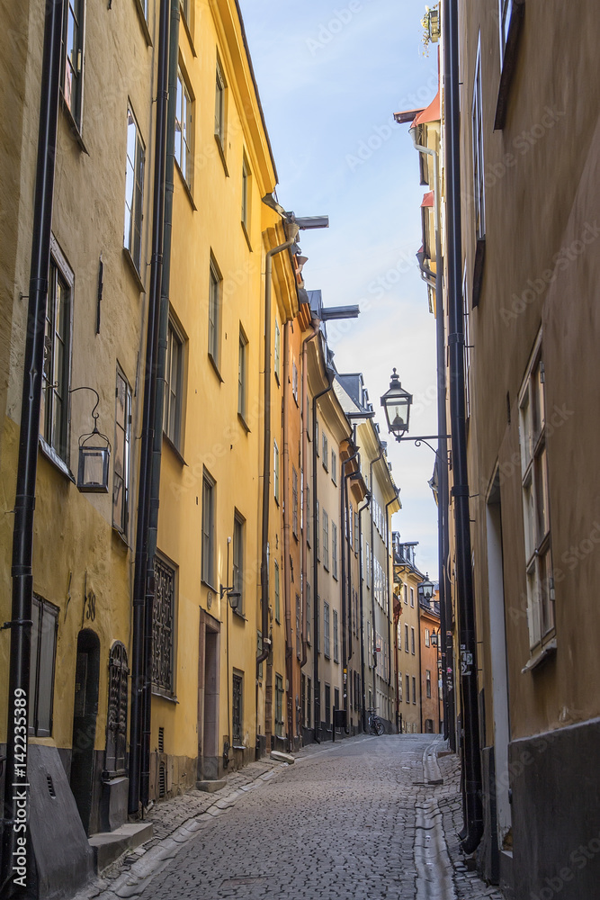 foot walk on  narrow street of Stockholm in  afternoon. High walls of close standing houses