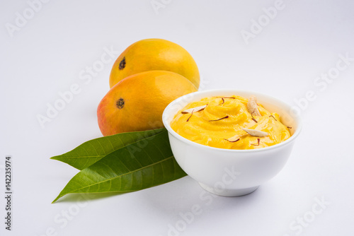 hapus or alphonso Mango pudding / Mango shrikhand or srikhand or amrakhand - Mango dessert with condensed milk magoes and nuts, selective focus over white background photo