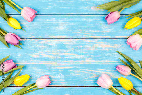 Fototapeta Naklejka Na Ścianę i Meble -  View of bunch of yellow and pink tulips on a blue wooden background