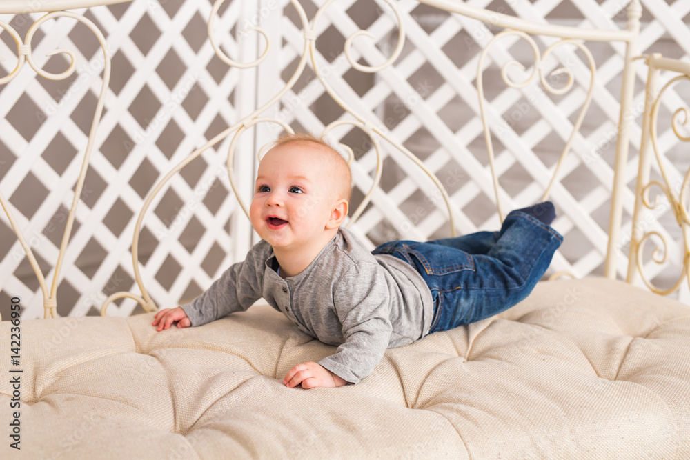 Adorable baby boy in white sunny bedroom. Newborn child. Nursery for young children. Family morning at home. Adorable baby boy in white sunny bedroom. Newborn child. Nursery for young children. Family morning at home.