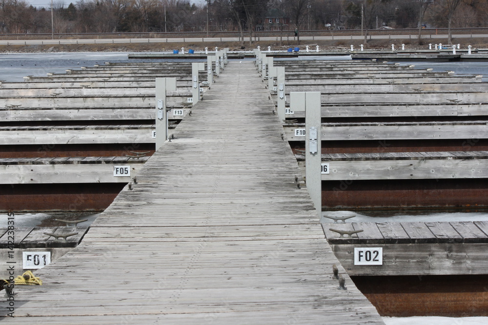 Empty boat slips during the early spring season in North America. Marina almost clear of ice. Empty boat slips during the early spring season in North America. Marina almost clear of ice.