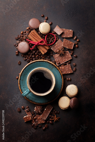 Coffee cup, chocolate and macaroons on old kitchen table
