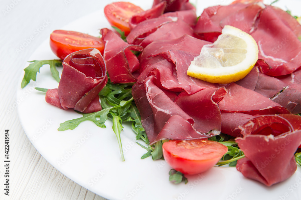 dish of bresaola and aragula