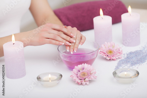 Nail Care. Closeup Of Beautiful Woman Hands With Natural Nails In Beauty Salon. Female Soaking Fingernails In Transparent Glass Bowl Full Of Water Indoors. Spa Manicure Concept. High Resolution