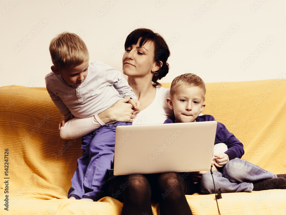 Two little boys and mother using laptop