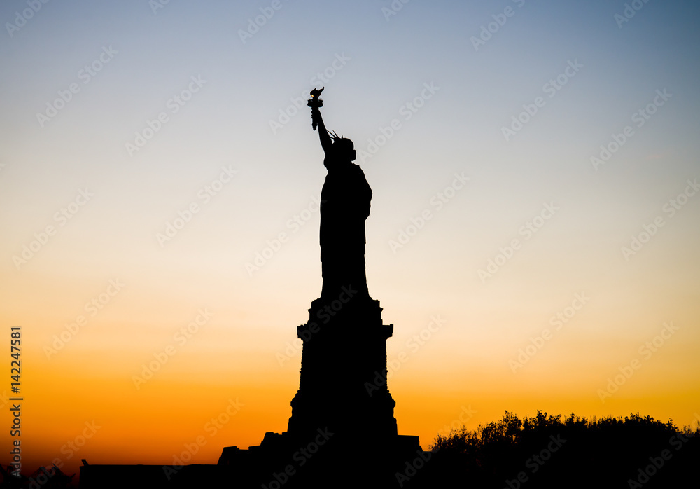 New York, USA - November 21, 2012: The Statue of Liberty silhouette against crimson sunset