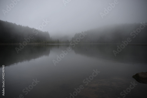 Bild auf Leinwand Mysterious dark lake in the morning mist
