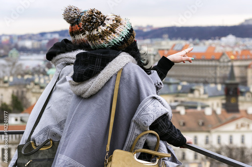 Two unrecognizable women look at the Prague city from the hill.