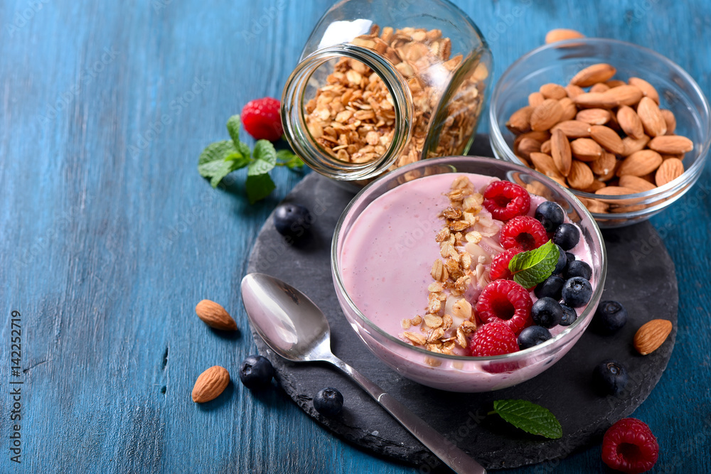 Smoothie bowl, pink yogurt with berries and almond, granola, healthy breakfast, vegan vitamin snack Smoothie bowl, pink yogurt with berries and almond, granola, healthy breakfast, vegan vitamin snack