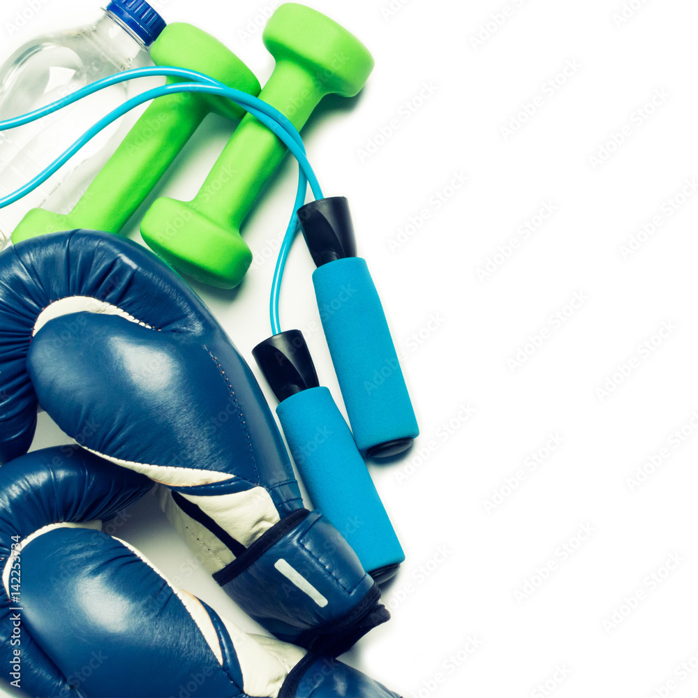 Fitness concept - boxing glove, dumbbells, skipping rope and bottle