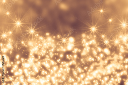 Golden abstract sparkles or glitter lights. Festive gold background. Defocused circles bokeh or particles. Template for design