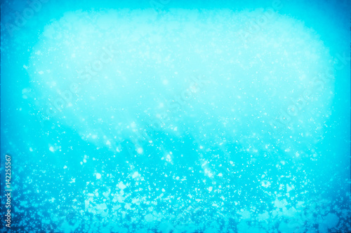 Abstract bokeh or glitter lights on blue background. Circles and defocused particles. Design template