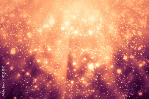 Golden abstract sparkles or glitter lights. Festive gold background. Defocused circles bokeh or particles. Template for design