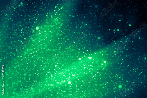 Green abstract background. Bokeh or round defocused particles or glitter lights