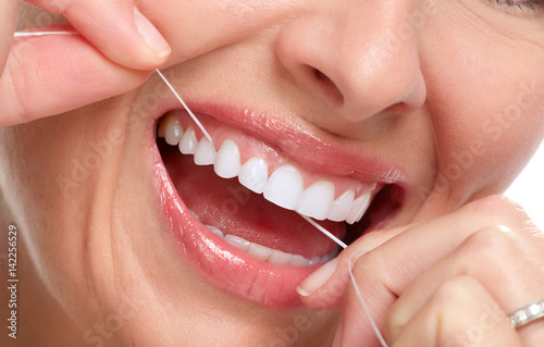 woman smile with tooth floss