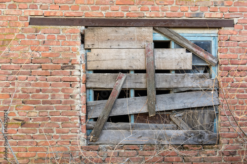 Old boarded-up window on brick wall