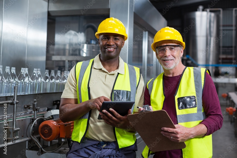 Factory workers with clipboard and digital tablet Factory workers with clipboard and digital tablet